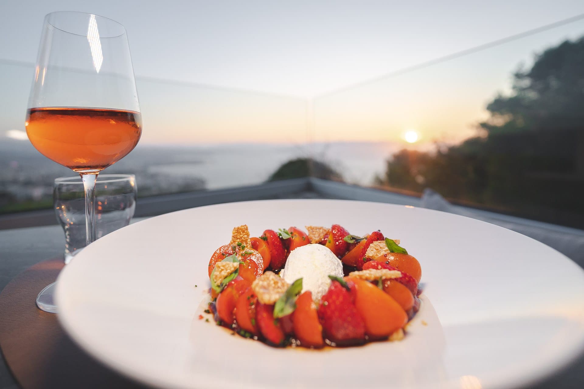 Strawberries and burrata, plated with the sunset behind.